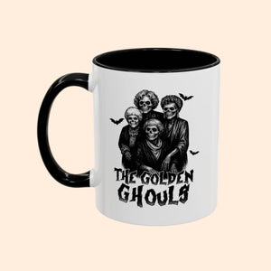 Mug with 'The Golden Ghouls' design featuring skeletons and bats on a white background.