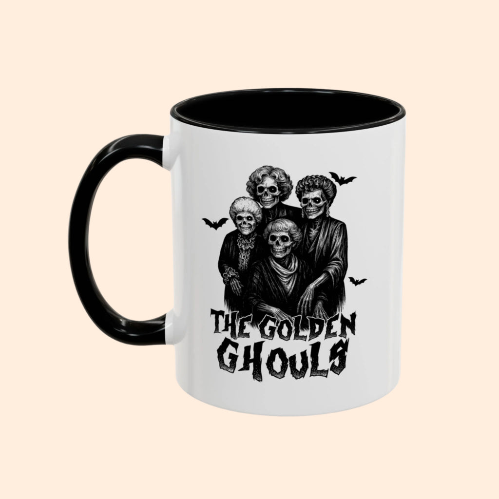 Mug with 'The Golden Ghouls' design featuring skeletons and bats on a white background.