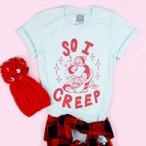 An image of the So I Creep Santa novelty Christmas shirt with a hat from Saturday Morning Pancakes.